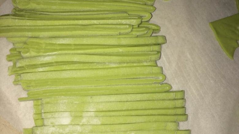 彩色手工蔬菜面,反复压面团,能使面条比较筋道,再用锋利的刀子切面,切成宽面片。