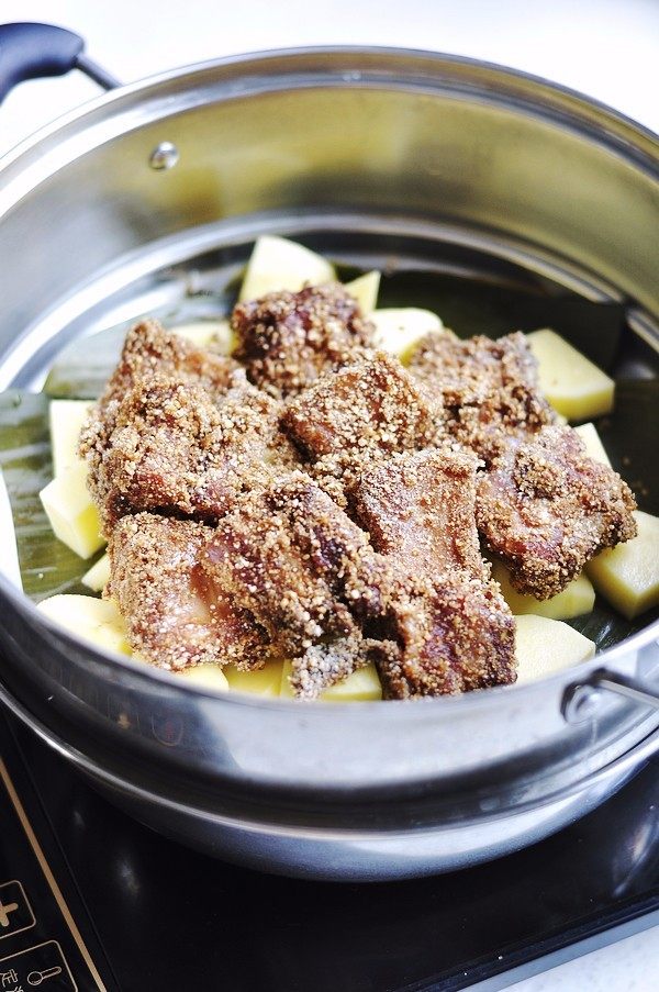 粉蒸排骨,把拌有蒸肉米粉的肋排码放在在土豆块上面。