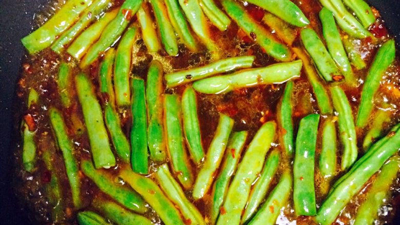 四季豆烧茄子,倒入四季豆,翻炒均匀后加入小半碗水,刚好淹没完四季豆