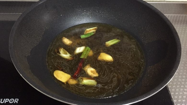 酥焖鲫鱼,倒入开水,没过鲫鱼的水量