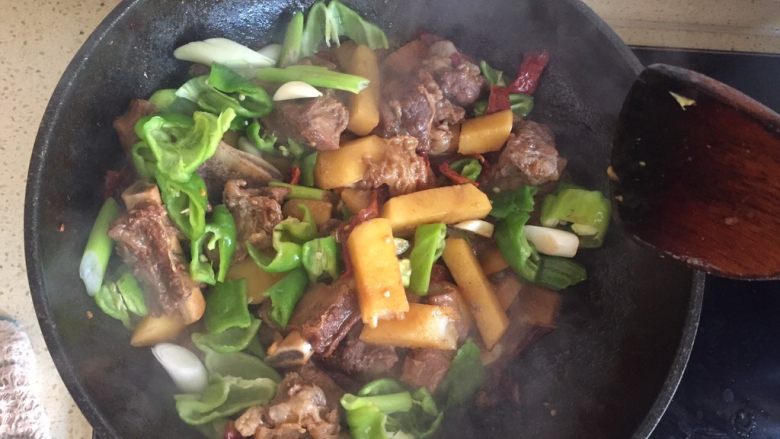 土豆烧排骨,汤汁变少后 加入青辣椒和大蒜 继续翻炒 尝一下咸淡 根据口味 加入适量调味料