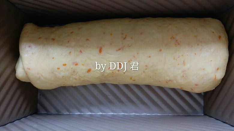 橙香蔓越莓土司,从上至下卷起,然后放入土司盒内。将土司盒放入烤箱进行二发