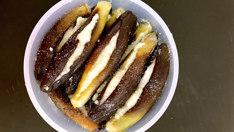 吃粥小菜 蒜香茄子,放在保鲜盒中,放满一层后就撒一层精盐