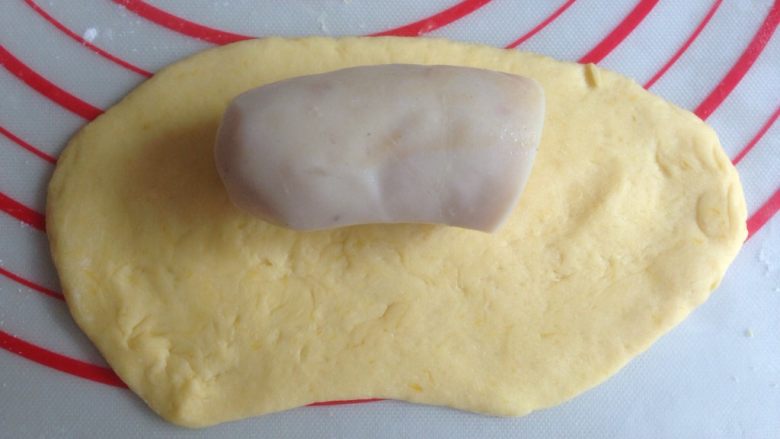 香肠锦鲤包,擀成长度13CM左右的椭圆形,其中一条长边向下擀薄一点,放上半根香肠