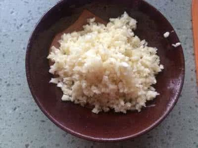 蒜蓉粉丝蒸虾,下面我们来做蒜蓉汁,锅内放2大匙油,冒白烟就放入蒜蓉炒出香味,放入所有调味料烧开即为蒜蓉汁