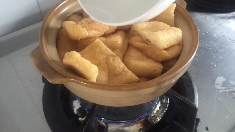 豆豉豆泡菠菜煲•斋菜,加四大碗热水盖出砂锅顶上边缘,水要尽量一次性加满锅,豆泡会吸很多的汤汁。(冷水入热砂锅有爆裂的风险。)