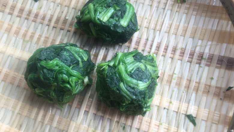 豆豉豆泡菠菜煲•斋菜,捞出,冲洗凉水后,充分挤干水份捏成菜团子。