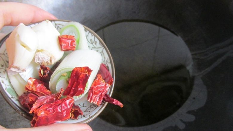 重庆鸡公煲,把锅里放油,下葱,干辣椒大蒜爆香。