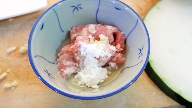 宝宝辅食之肉末蒸冬瓜+冰糖水蜜桃,先处理肉末。肉末加四分之一个鸡蛋清,一勺淀粉,一点蒜末拌匀,再淋少许油腌制