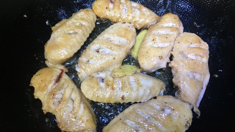 茭白烧鸡翅,约3分钟,煎至背面有点儿金黄色的时候就可以翻个面儿了,继续煎。腌制鸡翅的酱汁先留着备用哦,记得把姜片放进去,注意全程小火慢煎,不要煎糊了。