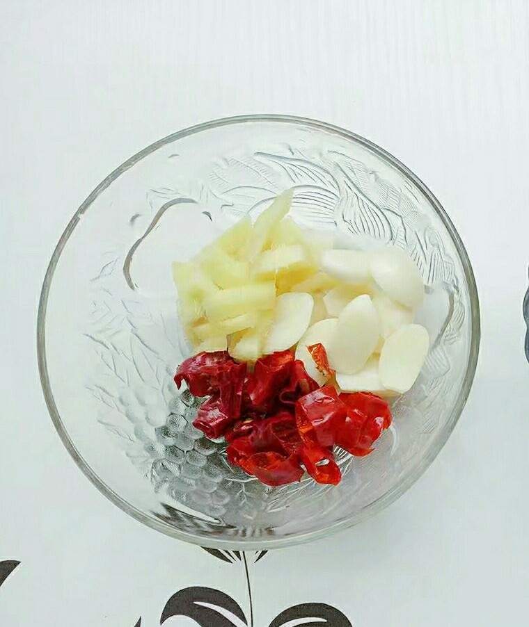 黄焖鸡,干辣椒切段,<a style='color:red;display:inline-block;' href='/shicai/ 2794'>大蒜</a>一分为二,姜切条装入小碗中备用