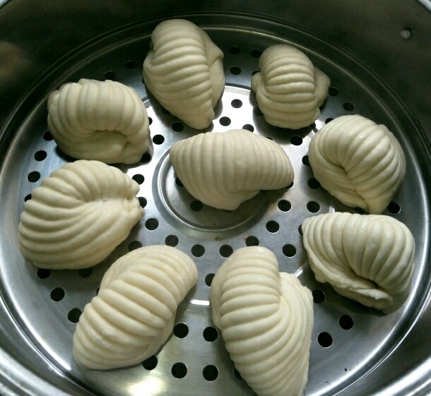 海螺馒头,进行第二次发酵,蒸锅做水烧开之后放入馒头,然后大火烧开之后转小火,20分钟即可