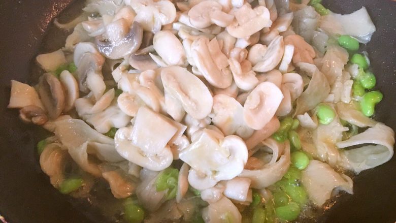 蘑菇炒水面筋,翻炒片刻后,倒入蘑菇(连汤汁)