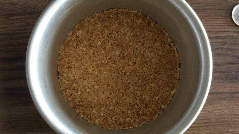 酸奶芝士,将拌好的饼干碎倒入模具中压实。