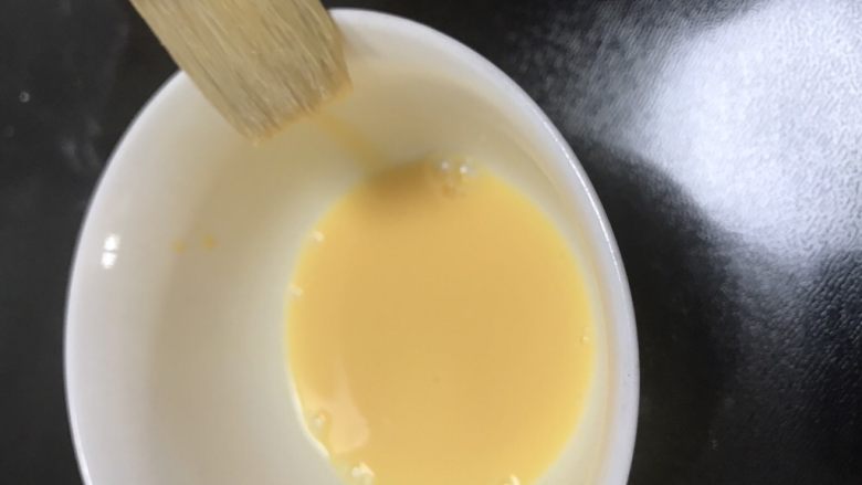 广式巧克力莲蓉月饼,一个蛋黄加10克水调均匀后过筛两边,刷子要在碗边刮两下再刷到月饼上面,蛋液太多表面容易糊