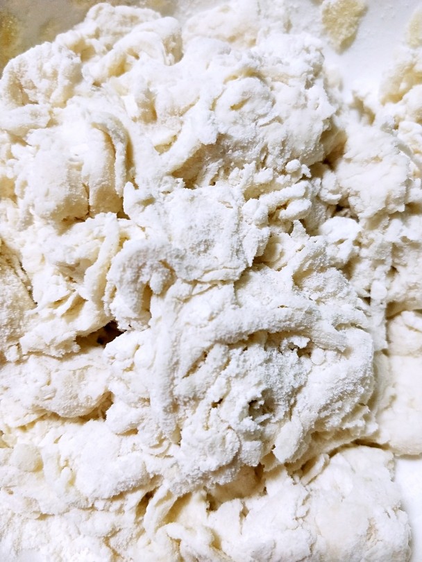史努比馒头,把除竹碳粉以外的所有材料放入面粉中边倒入温水边搅拌……搅成棉絮状(如图)