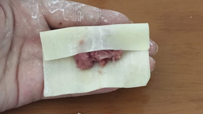 宝宝煎饺,馄饨皮四周用手指或筷子沾上水。取三分之一处对折。
tip:一般买来的馄饨皮,需要沾点水才会粘的住。以免肉馅漏出来。