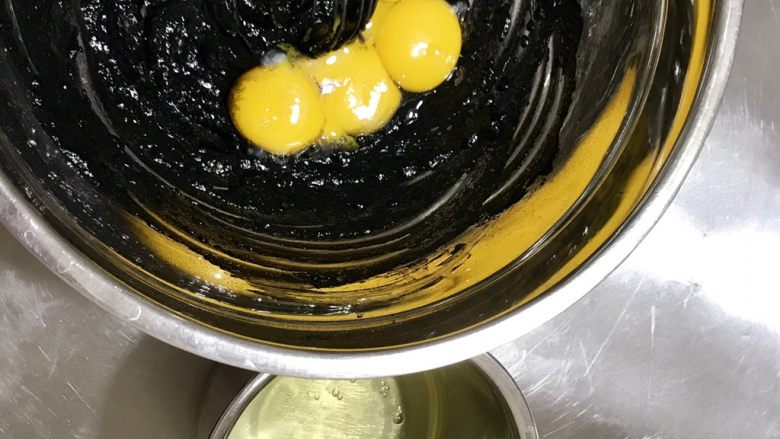 黑·竹炭咸奥利奥蛋糕卷,蛋黄和蛋白分离,蛋黄加入面糊中,用手动打蛋器拌匀,蛋白放到另一个无油无水的打蛋盆中