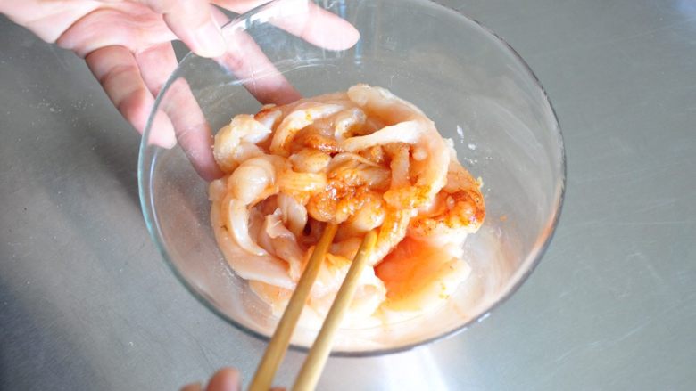 街头小吃自己做---香酥无骨鸡柳,将调味料和鸡胸肉混合均匀,覆盖保鲜膜放进冰箱冷藏腌渍2小时。