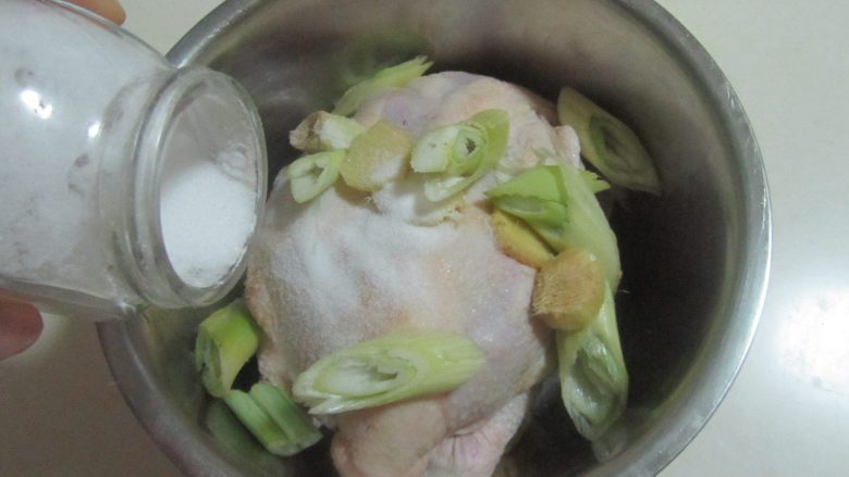 烤鸡(电饭煲版),鸡放入容器中, 加入适量姜葱蒜和适量的盐;