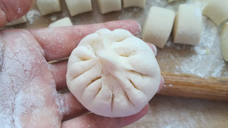 包菜馅素包子,最后收口,一个包子就包好了(如果不会包建议去搜包包子视频,看几遍就会了)。
