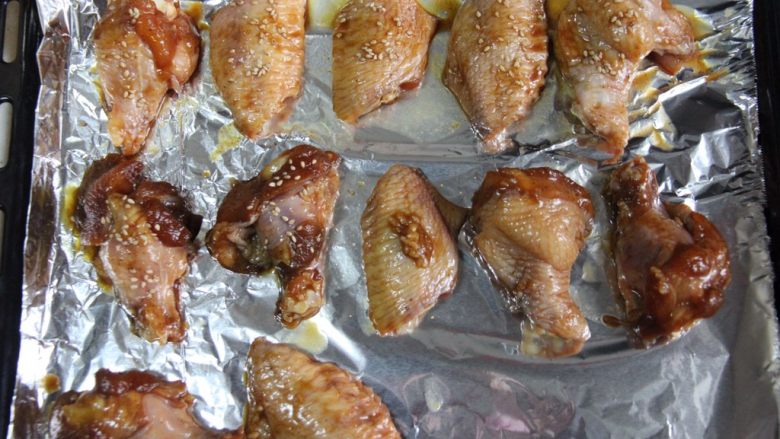 烤鸡翅,码入烤盘，撒少许芝麻，上下火180度，40分钟，中间翻面一次