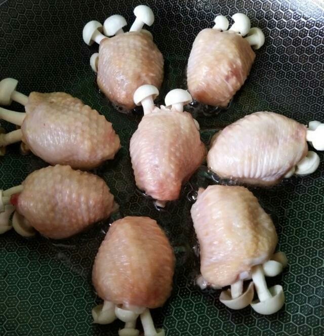 (家常菜)鸡翅包白玉菇,锅中下入油烧热,然后下入包好白玉菇的鸡翅煎,煎至两面都金黄盛出备用