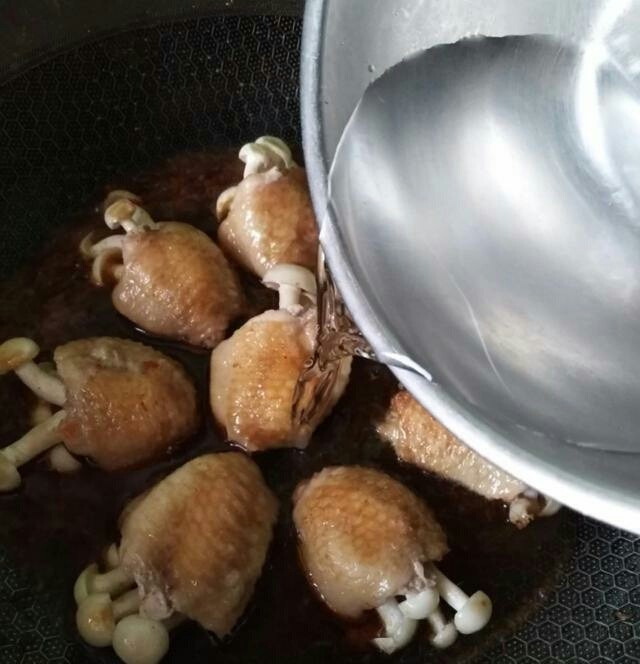 (家常菜)鸡翅包白玉菇,把煎好的鸡翅下入锅中,加入水,水与鸡翅平行就可以
