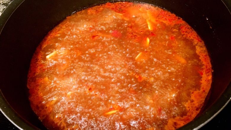 红油水煮肉片,加入适量的水,烧开,此时的汤已经非常红了,但并不会很辣。