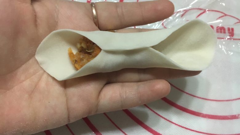 金鱼饺子,面皮对折,将中间部位的面皮轻轻捏紧,看上图。
