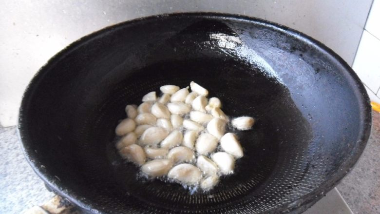 葱头大蒜烧鱿鱼, 热油,放入大蒜,小火炒慢慢炒制