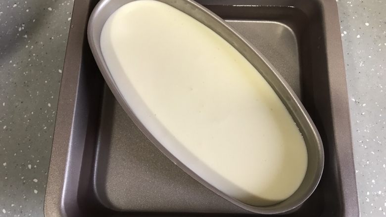 轻乳酪蛋糕,取一个烤盘倒入温水,芝士模具放入烤盘,水没过模具一半左右。烤盘放入烤箱底层,将温度调至上下火130度烤90分钟。