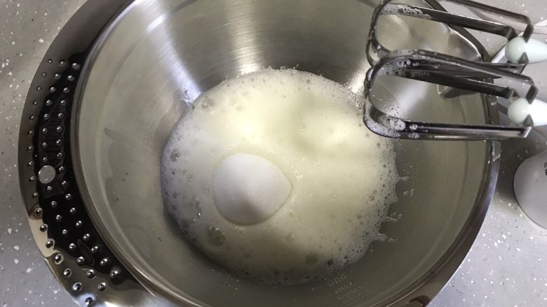 轻乳酪蛋糕,开动打蛋器低速将蛋清打至粗泡状态,一次性加入细砂糖,继续高速打发至湿性发泡。