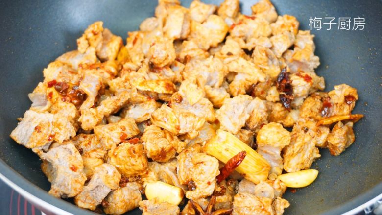 红烧牛肉面,倒入牛肉粒,翻炒均匀。