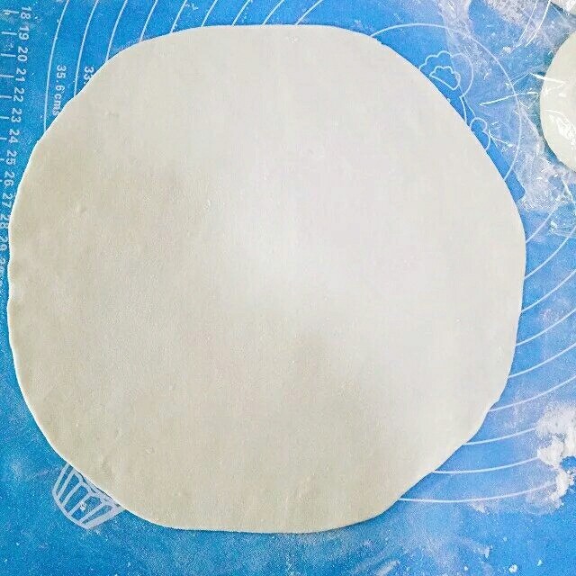 韭菜鸡蛋饼,取一个剂子,下面撒少许干面粉,赶成薄薄的的圆皮