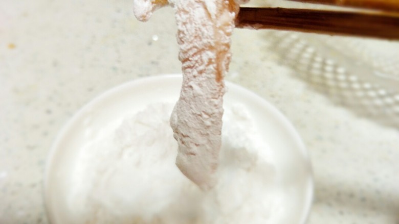 (鸡胸版)糖醋里脊,夹起裹匀蛋清的鸡胸肉在生粉里沾一下,均匀的沾上生粉。