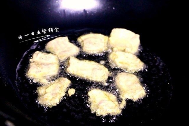 菠萝咕咾肉,加入淀粉,让每一片肉都均匀的沾上淀粉。炒锅放油,油热将肉片一片片下入油锅,炸至金黄,关火。