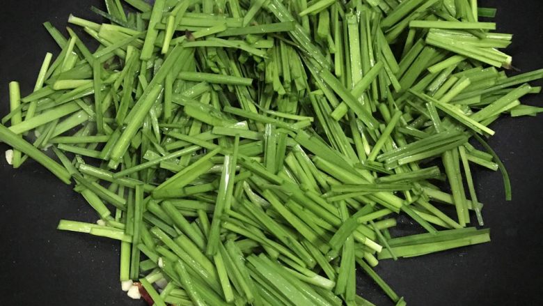 韭菜煎豆腐,下韭菜翻炒,加盐。