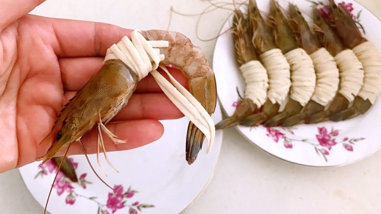 颜值爆表的 香酥玉带虾,取一只海青虾,用泡好的3根面条缠住中间虾肉部分