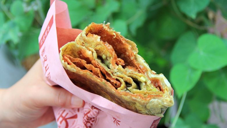 天津老味煎饼果子,这就是正宗的天津老味煎饼果子 。
我们天津人吃东西比较豪迈,喜欢一手拿着一套煎饼果子,一手端着一杯豆浆,大口大口地咬着吃,感觉有点市井,其实这就是生活,当然还是有好多人很斯斯文文的端庄高雅的吃煎饼果子。不管怎么吃,我们探寻的都是那种老味道的美食。