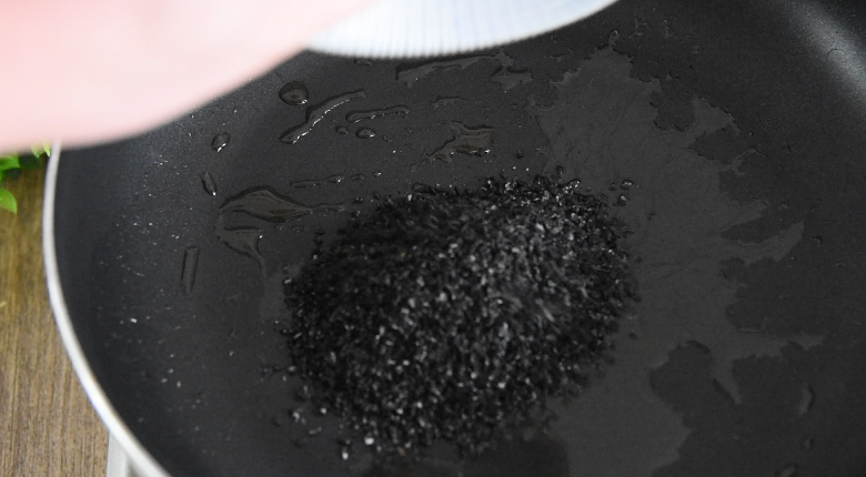 大厨手把手教你做红薯饼,美味零食新做法!,锅中倒入20g花生油,倒入黑芝麻炒香