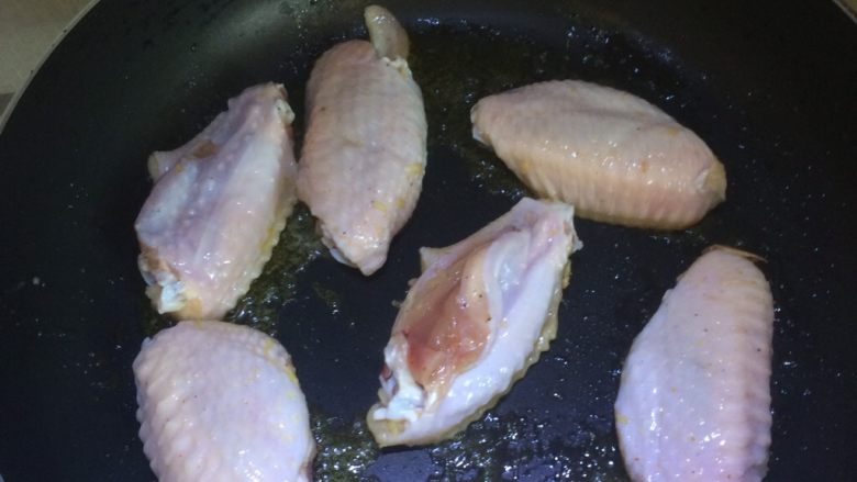 可乐鸡翅,冷锅入油，油热至七成下鸡翅。