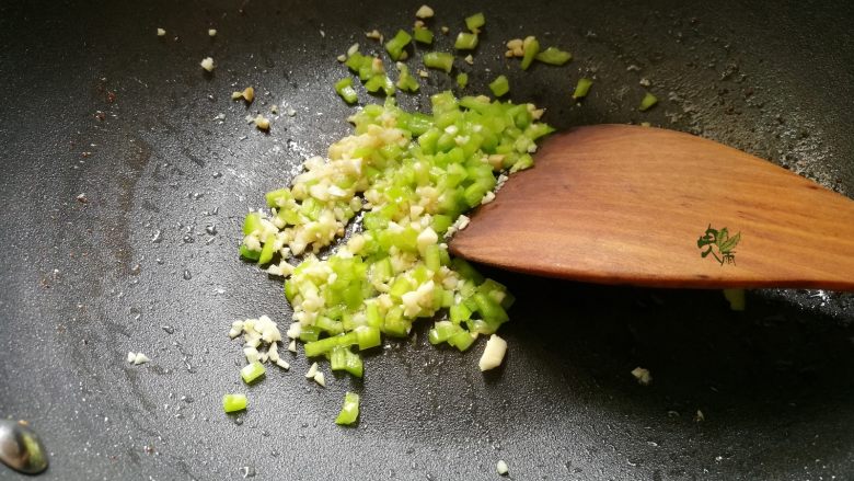 吮指椒盐排骨,将炸过的油倒出,锅里放入蒜末,青椒炒出香味。