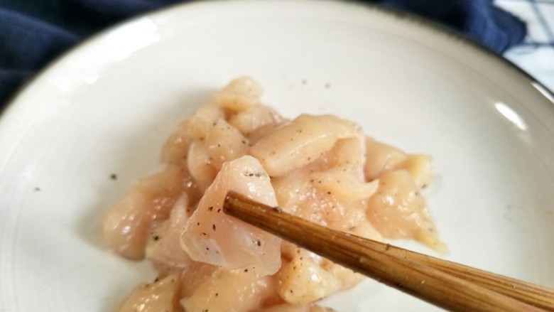 口蘑芦笋炒鸡胸,撒上一勺盐和一些研磨黑胡椒,抓匀腌制几分钟。