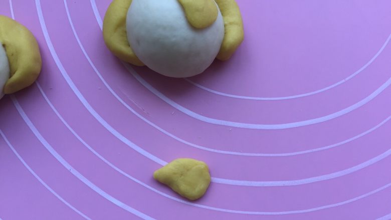 卡通狗狗馒头,然后把剩下的一个南瓜面团四等份分开,捏成如图形状,贴在一侧眼睛处。