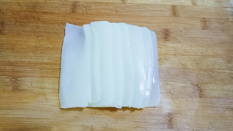 凉拌凉粉,先把凉粉切成薄片,在切成条状,放入碗中。切的薄、细一些容易入味,