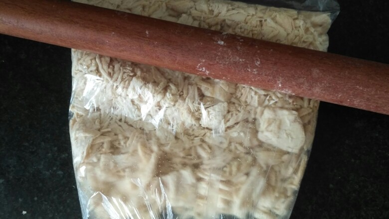 自制鸡肉松,煮好后沥干水,装进保鲜袋,用擀面杖先擀碎,再拍打松。