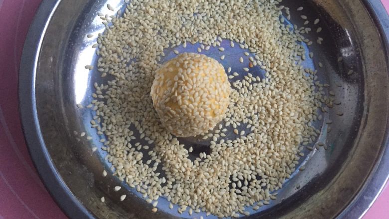 豆沙南瓜饼,放入芝麻盆里,使其360度无死角沾满芝麻。