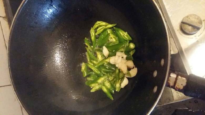 酸姜鸭脚,热锅下油,放入青椒蒜米,炒至虎皮状。期间放少许盐
