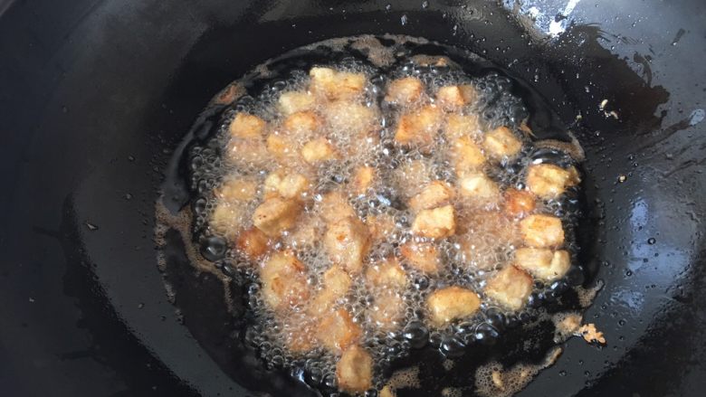 酸甜里脊,油温六成热时下入肉丁先中火炸至定型,再小火炸熟